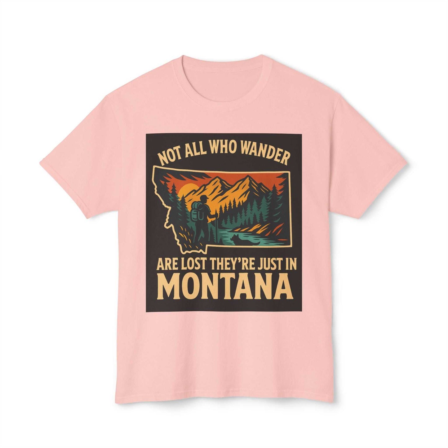 Montana Adventure Tee with nature-inspired design and text "Not all who wander are lost they're just in Montana" on a soft pink background.