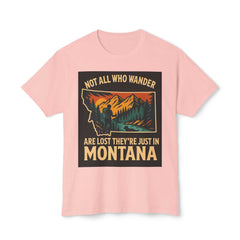 Montana Adventure Tee with nature-inspired design and text "Not all who wander are lost they're just in Montana" on a soft pink background.