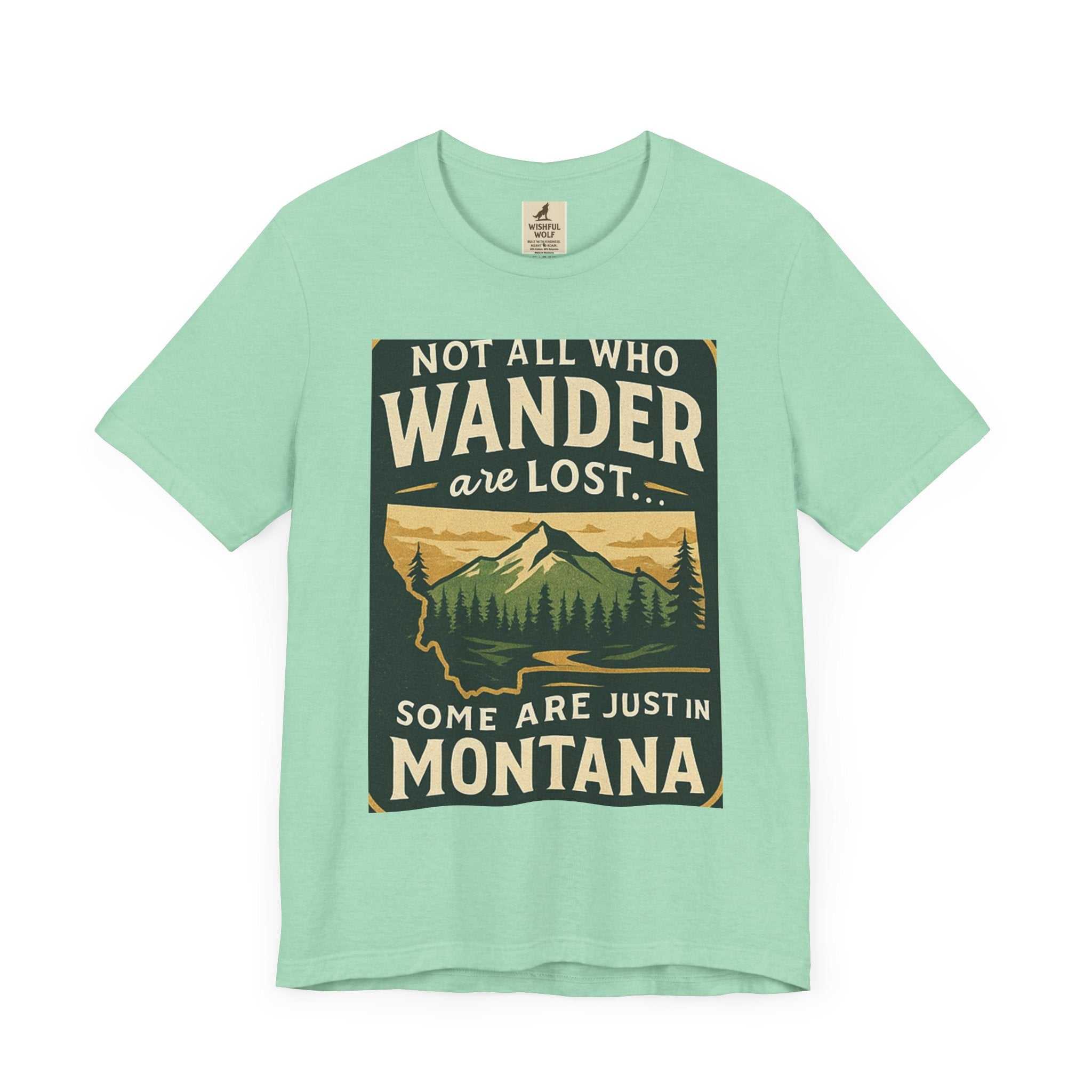Get Lost in Montana Tee with scenic mountain graphic and "Not all who wander are lost... some are just in Montana" quote on mint green background.